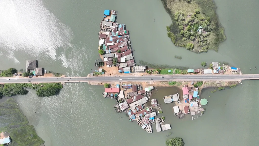 habitat riverain installé de part et d'autre de la route, sur les berges du lac Ahémé
