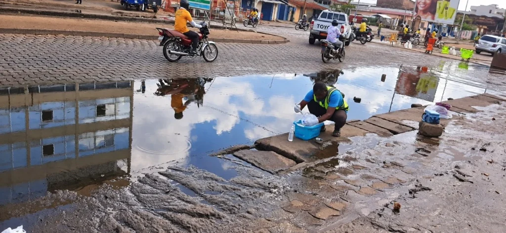 prélèvement d'eau sur un axe urbain inondé de Cotonou